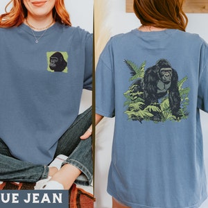 May include: A blue jean t-shirt with a gorilla graphic on the front and a gorilla graphic in a jungle scene on the back. The text "BLUE JEAN" is printed on the bottom of the image.