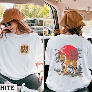 Op de afbeelding: Wit T-shirt met een tijgergezicht-print op de voorkant en een tijger in een bamboebos-print op de achterkant.