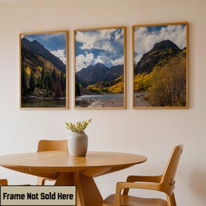 May include: Three framed landscape prints depicting mountain scenery with a lake and trees in autumn colors. The frames are light brown. The text "Frame Not Sold Here" is at the bottom.