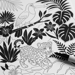 May include: Black and white illustration of a toucan perched on a branch, a leopard cub, and tropical foliage. The image is a coloring page with a marker in the lower right corner.