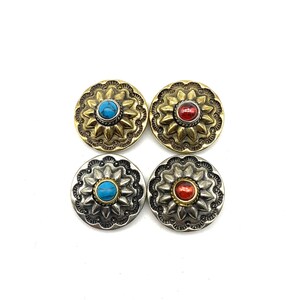 May include: Four decorative metal buttons with a flower design and a gemstone centre. Two buttons are gold with turquoise gemstones and two buttons are silver with red gemstones.