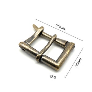 May include: A brass buckle with a rustic finish, measuring 56mm by 38mm and weighing 65g.