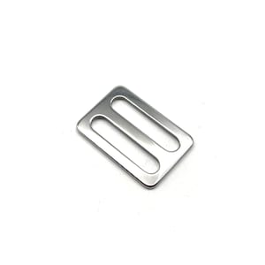 May include: Silver metal slider buckle with two slots.