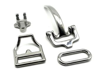 May include: A set of four silver metal belt buckle components. The set includes a buckle, a keeper, a loop, and a prong.