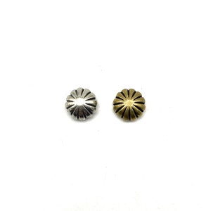 May include: Two metal buttons, one silver and one gold, with a sunburst design.