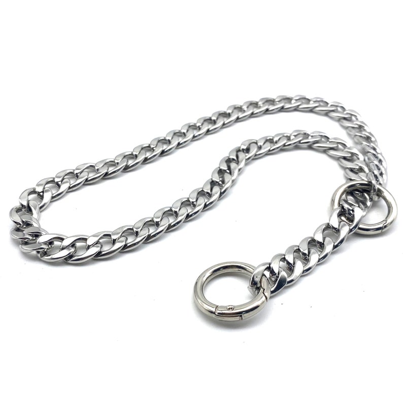 May include: A silver curb chain dog collar with two silver D-rings.