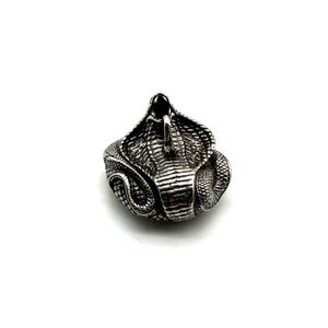 May include: A silver ring with a detailed cobra design. The ring shows the cobra's head and hood, with intricate scales and a raised, striking pose. The ring is likely made of metal and is set against a white background.