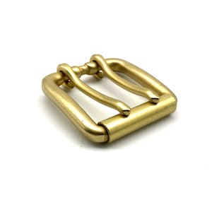 Könnte beinhalten: Massive Messing-Gürtelschnalle mit rechteckigem Rahmen und Mittelsteg. Die Schnalle hat ein klassisches Design mit polierter, goldener Oberfläche. Die Hardware eignet sich für Ledergürtel und andere Bastelprojekte.
