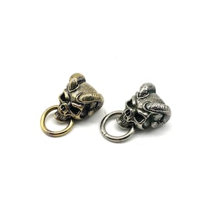 May include: Two skull keychains with horns, one is gold and the other is silver.