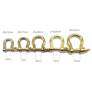 May include: Five gold-colored metal D-rings with a screw pin closure. The rings are arranged in order of size from left to right, with the smallest ring measuring 6mm and the largest ring measuring 10mm. The rings are labeled with their dimensions in millimeters, such as 20x15mm, 22x17mm, 25x20mm, 27x22mm, and 30x23mm.