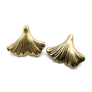 May include: A pair of gold-tone earrings shaped like ginkgo leaves.