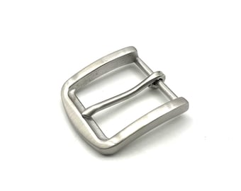 May include: A silver metal belt buckle. The buckle has a rectangular frame with a curved bar. The metal has a brushed finish. The design is simple and modern, suitable for various belt styles.