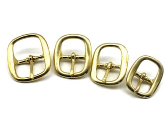 May include: Four gold-toned metal belt buckles of different sizes. The buckles are rectangular with a rounded edge and a centre bar.