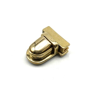 Pode incluir: Um fecho de metal dourado com uma parte superior arredondada de forma oval e uma base retangular. O fecho é projetado para ser usado para proteger bolsas ou outros itens.