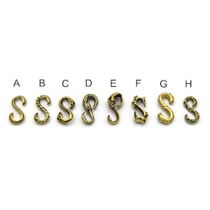 May include: Eight different gold-colored metal hooks in the shape of the letter "S" with various designs. The hooks are labeled A through H.