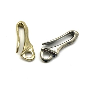 May include: Two metal key hooks. One is a shiny gold color, and the other is silver. Both have a curved hook shape with a circular opening at the base. The hooks are designed for attaching to keychains or other items.