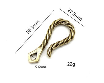 Pode incluir: Um gancho de metal dourado com um design de corda trançada. O gancho mede 5,6 mm de largura, 27,3 mm de altura e 58,3 mm de comprimento. Ele pesa 22 gramas.