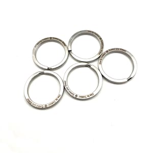 May include: Five silver key rings with the inscription "Live by Instinct Control your Kismet" engraved on each ring.