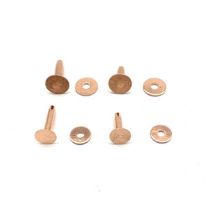 May include: Six rose gold metal rivets with a round head and a short shank. Each rivet is paired with a matching washer.