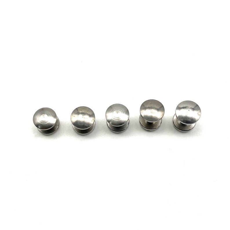 May include: Five silver metal round-headed push buttons.