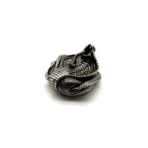 May include: A silver-coloured cobra figurine, coiled and ready to strike. The snake's scales are intricately textured, and its hood is raised. The figurine is set against a plain white background, highlighting the detailed craftsmanship.