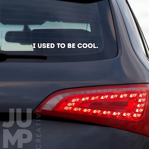 Peut inclure: Une voiture noire avec un autocollant en vinyle blanc sur la lunette arrière qui dit "J'étais cool."