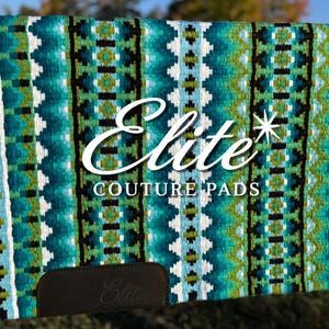 May include: A turquoise, green, and white patterned saddle pad with black trim. The pad has the text "Elite COUTURE PADS" in white script. A brown leather patch with the word "Elite" is on the bottom.