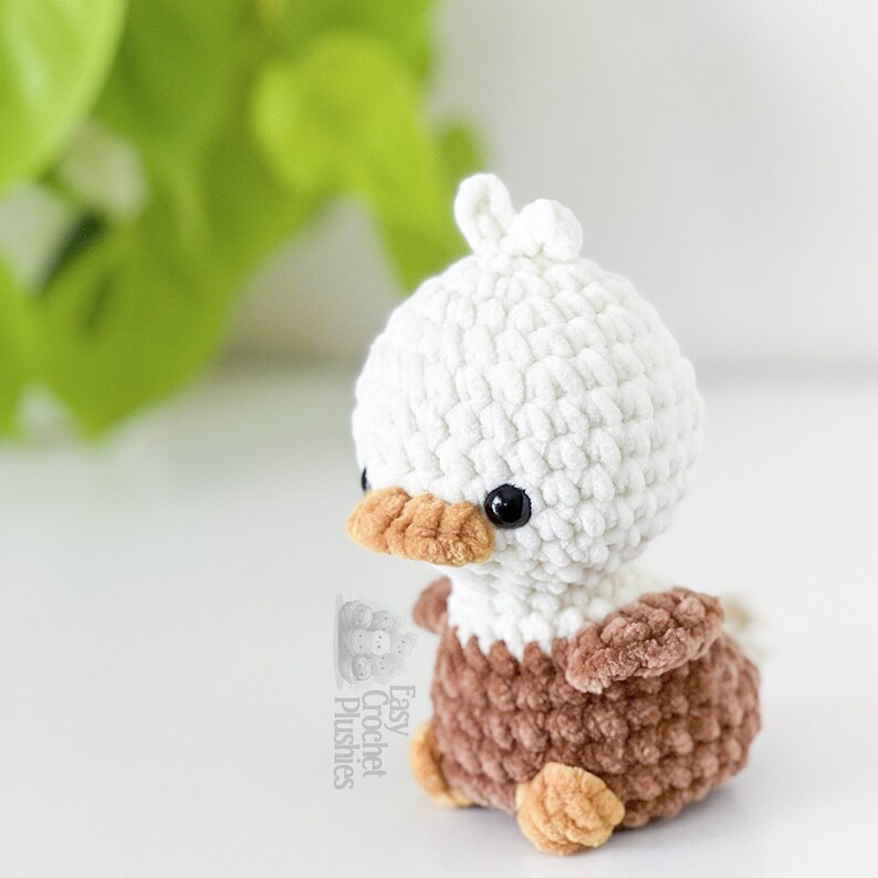 Peut inclure: Une petite peluche crochet&eacute;e &agrave; la main repr&eacute;sentant un pygargue &agrave; t&ecirc;te blanche avec une t&ecirc;te blanche, un corps marron et un bec ainsi que des pattes marron clair. Le jouet a des yeux de s&eacute;curit&eacute; noirs et une touffe de laine blanche sur le dessus.