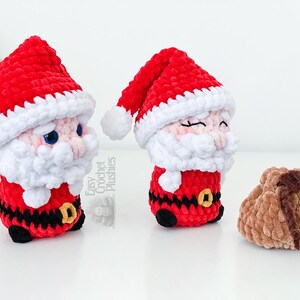 May include: Two handmade crochet Santa Claus figures with red hats and white beards, and a small brown pouch. The Santa figures have black belts with gold buckles. The text "Easy Crochet Plushies" is visible.