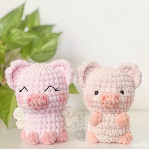 May include: Two handmade crochet pig plushies in shades of pink. One pig has closed eyes, blush, and small white wings. The other pig has open eyes and blush. The text "Easy Crochet Plushies" is visible on the right.