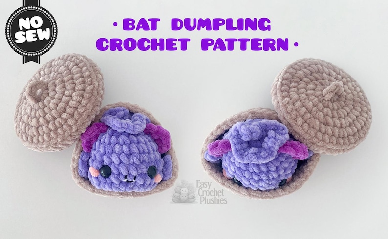 May include: A crochet pattern titled BAT DUMPLING CROCHET PATTERN with a NO SEW badge. The image displays two plush bats, each nestled inside a light brown crocheted shell. The bats are purple with dark purple ears, black eyes, and pink cheeks.