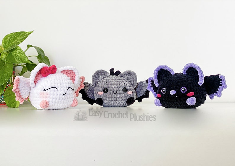 Puede incluir: Tres peluches de murci&eacute;lago de crochet con diferentes colores de pelaje. El primer murci&eacute;lago es blanco con alas rosadas y un lazo rosa. El segundo murci&eacute;lago es gris con alas negras. El tercer murci&eacute;lago es negro con alas moradas. Los tres murci&eacute;lagos tienen ojos negros y mejillas rosadas.
