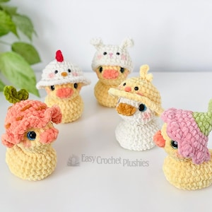 May include: Five handmade crochet duck plushies, each wearing a different hat. The ducks are yellow with orange beaks and blue eyes. Hats include a chicken, bunny, and mushroom design. The text "Easy Crochet plushies" is visible.