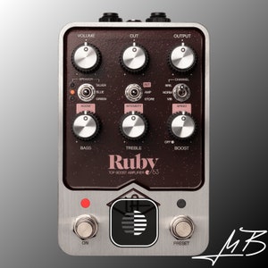 Puede incluir: Primer plano de un pedal de guitarra marrón oscuro con botones plateados y una placa frontal plateada. El pedal está etiquetado como "Ruby Top Boost Amplifier '63".