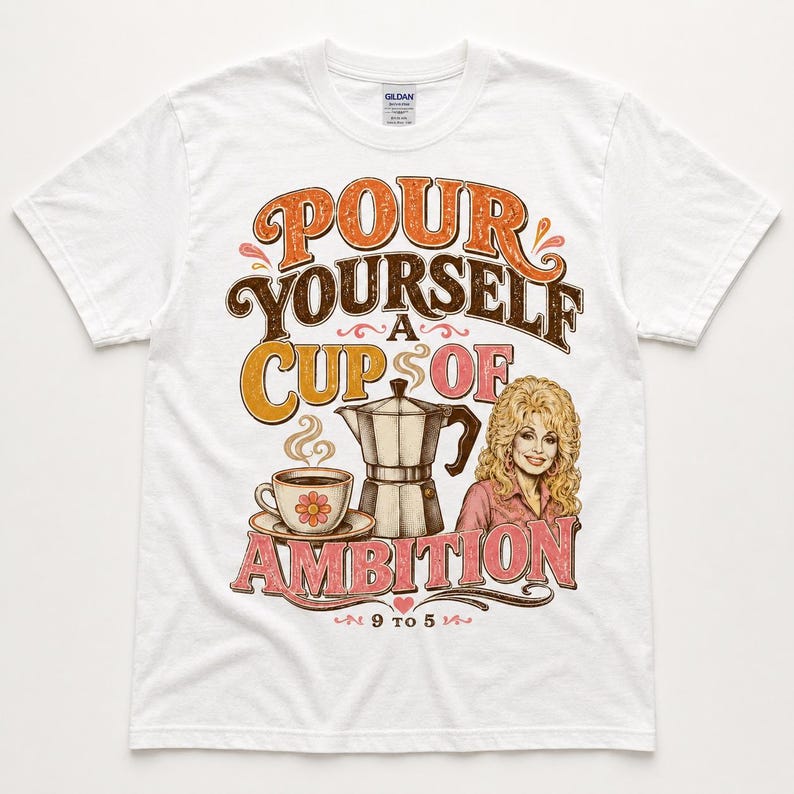 May include: A white short-sleeve t-shirt featuring a graphic print with the text "POUR YOURSELF A CUP OF AMBITION" and "9 TO 5". The design includes a coffee cup, a moka pot, and an illustration of a blonde person with wavy hair.