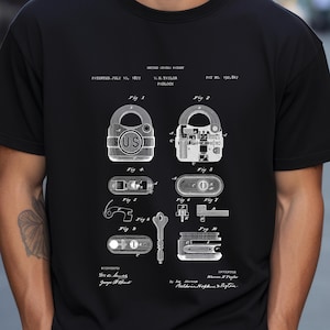 May include: Black t-shirt featuring a detailed white diagram of a padlock, including internal components and a key. The diagram is labeled with patent information, including the date July 10, 1877, and the name W.H. Taylor. The shirt has a classic crew neck.