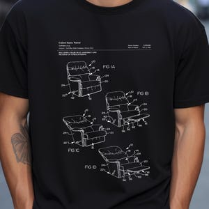 May include: Black t-shirt featuring a white diagram of a recliner chair assembly and method of upholstering. The diagram includes multiple views labeled FIG IA, IB, IC, and ID, with detailed component labels.