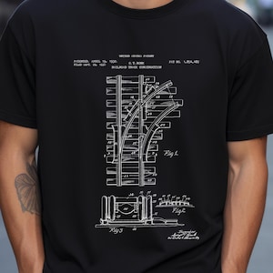 May include: Black t-shirt with a white diagram of a railroad track construction. The design includes detailed diagrams, labels, and the text "UNITED STATES PATENT" and "RAILROAD TRACK CONSTRUCTION".