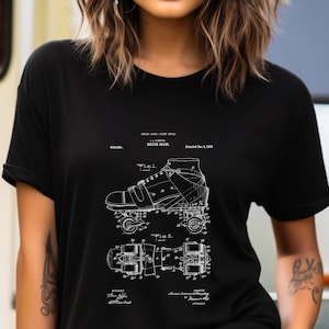 May include: A black short-sleeved t-shirt featuring a white graphic print of a vintage roller skate patent illustration. The design includes technical line drawings labeled Fig. 1 and Fig. 2, along with text detailing the patent number 900,001 and date.