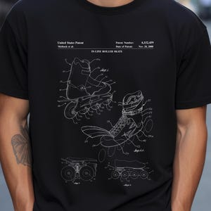 Könnte beinhalten: Ein schwarzes T-Shirt mit einem weißen Grafikdruck eines US-Patents für einen Inlineskate. Das Design enthält technische Strichzeichnungen des Skates, die Patentnummer 6.152.459 und das Datum vom 28. November 2000.