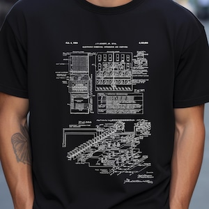 Peut inclure: Un t-shirt noir avec un imprimé blanc d'un brevet pour un "Electronic Numerical Integrator and Computer" daté du 4 février 1964. Le brevet comprend des diagrammes et du texte décrivant l'invention.