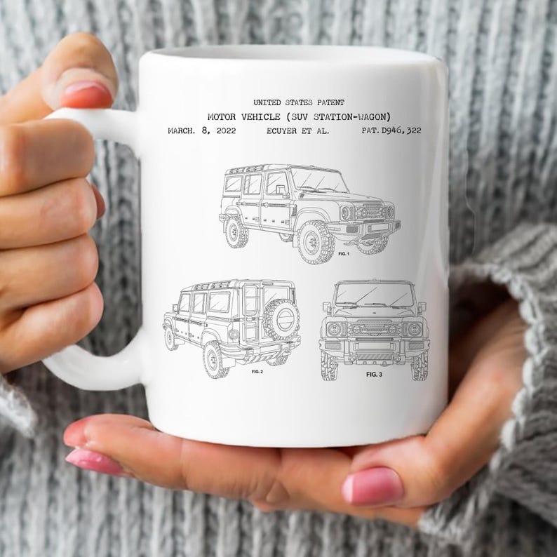 A person is holding a white mug with black line drawings of three different types of vehicles, including a car and a truck, along with text that appears to be a technical drawing or specifications related to the vehicles.
