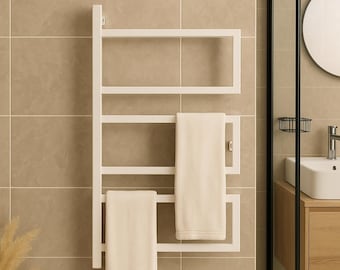 Puede incluir: Un toallero blanco montado en la pared con dos toallas de color crema colgadas. El toallero tiene un diseño rectangular y está montado en una pared de azulejos beige. El entorno del baño incluye una mampara de ducha, un lavabo y un espejo.