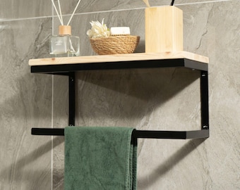 May include: A wall-mounted bathroom shelf with a natural wood top and black metal frame. It features a towel bar, a green towel, and decorative items like a reed diffuser and a small basket with soap.