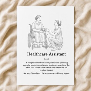 May include: A white print featuring a line drawing of a healthcare assistant kneeling beside a person in a wheelchair. The text reads: Healthcare Assistant (noun): A compassionate healthcare professional providing essential support, comfort and kindness.