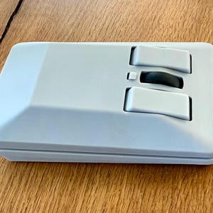May include: A white computer mouse with two buttons and a scroll wheel. The mouse has a unique, angular design.