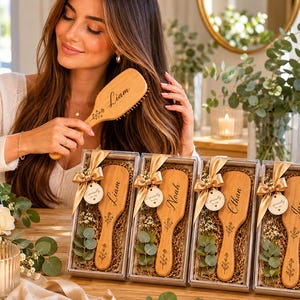 May include: Four rectangular gift boxes containing light brown wooden hairbrushes with engraved names Liam, Noah, Ethan, and James. Each brush features a floral design, a gold ribbon, and a small circular tag reading Especially for you.