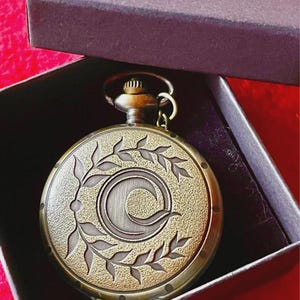 Elegante Vintage-Taschenuhr mit C-Motiv und Olivenblättern