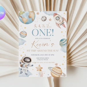 May include: A white invitation with a blue and gold space theme. It says "5, 4, 3, 2... ONE! Join us to celebrate Kevin's 1st trip around the sun! Saturday, July 4th at 2PM 2630 Space Drive Dallas, Texas RSVP to Anna at 456-7890".