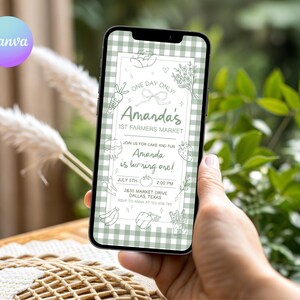 May include: A smartphone displays a digital invitation for Amanda's 1st Farmers Market. The invitation features a green gingham pattern background with illustrations of vegetables and fruits. Text includes the date, time, and location in Dallas, Texas.